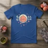 Cute peach with "もも 宜顔" text on a blue t-shirt, surrounded by pink cherry blossoms