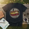 Black t-shirt with circular retro design text "My Aunt Is Definitely Cooler Cooler Than My Dad" and a smiling flower