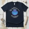Navy t-shirt with white text "My birthstone is a SEASHELL" above a colorful seashell graphic