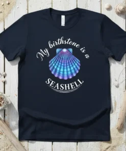 Navy t-shirt with white text "My birthstone is a SEASHELL" above a colorful seashell graphic