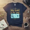 Navy blue t-shirt with "my brain is 90% song LYRICS" in gold and white typography, surrounded by musical notes and