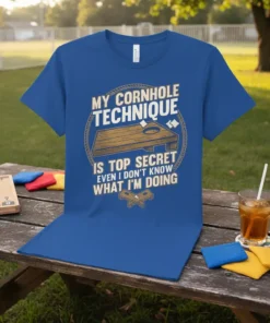 Blue t-shirt with "MY CORNHOLE TECHNIQUE IS TOP SECRET EVEN I DON'T KNOW WHAT I'M DOING" text and a cornhole