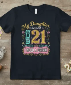 T-shirt with gold and pink text saying "My Daughter turned 21 I NEED A DRINK!" for a 21st birthday celebration