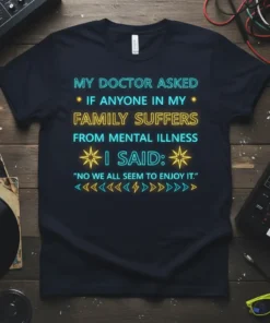 Dark t-shirt with neon-style text quote "MY DOCTOR ASKED IF ANYONE IN MY FAMILY SUFFERS FROM MENTAL ILLNESS I SAID