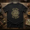 Black t-shirt with "MY DOG LOVE my HEART" text in a decorative golden font, surrounded by paw prints and floral