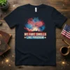 Navy blue t-shirt with "My Fart Smells Like Freedom" text in red and white, set against a backdrop of colorful