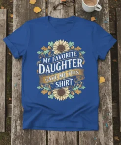 Text "My Favorite Daughter Gave Me This Shirt" with sunflower and oak leaf border on a royal blue t-shirt