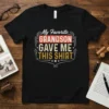 Black t-shirt with "My Favorite GRANDSON GAVE ME THIS SHIRT" text in vintage distressed font and decorative borders