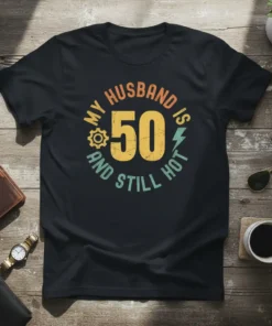 My Husband Is 50 And Still Hot text design with vintage style and graphic elements on a black t-shirt