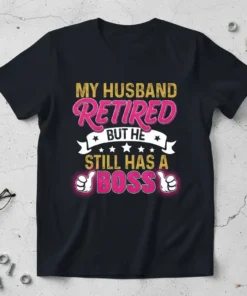 Black t-shirt with "MY HUSBAND RETIRED BUT HE STILL HAS A BOSS" text in pink and gold, featuring thumbs up