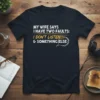 Black t-shirt with white and yellow text: "MY WIFE SAYS I HAVE TWO FAULTS: I DON'T LISTEN & SOMETHING ELSE"