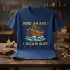 Navy blue t-shirt with gold text "Need an Ark? I Noah Guy" featuring a graphic of Noah's Ark on waves