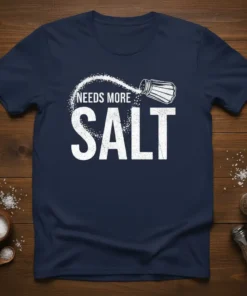 Needs More Salt text and salt shaker graphic on a navy blue t-shirt, ideal for foodies and chefs