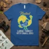 Blue t-shirt with "Nested Large Turkey With Small Bird" text and graphic of a large yellow turkey silhouette with a