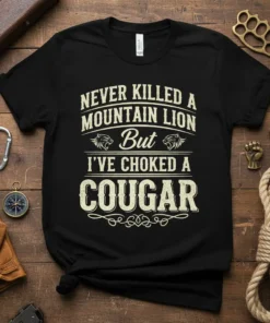 Black t-shirt with white text design that reads "Never Killed A Mountain Lion But I've Choked A Cougar" featuring lion