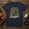 T-shirt design featuring muscular arms, mountains, and the text "Never Killed A Mountain Lion But I've Choked A Cougar"