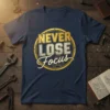Navy blue t-shirt with "Never Lose Focus" text in gold and silver lettering, featuring a circular gear graphic