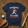 Never Underestimate The Left-Handed Pitcher text with baseball pitcher graphic on navy t-shirt