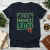 Navy blue t-shirt with "Nice Naughty Greek" text in green lettering, surrounded by a holly wreath border