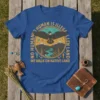 T-shirt with "NO HUMAN IS ILLEGAL WE WALK ON NATIVE LAND" text and an eagle graphic, mountains, and river
