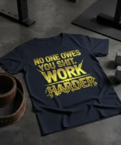 Motivational "NO ONE OWES YOU SHIT. WORK HARDER." quote in gold distressed font on a navy t-shirt, gym setting