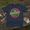 No Roundup design t-shirt featuring a red prohibition sign with leaves and skulls, and the word ROUNDUP in green