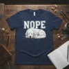 Nope text above a sleeping white dog graphic on a navy blue t-shirt