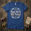 Nope! We're Not Twins! text design in a decorative circular frame on a blue t-shirt