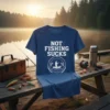 Blue t-shirt with white text "NOT FISHING SUCKS" and a graphic of a fisherman in a boat catching fish