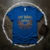 Blue t-shirt with "not today, satan" in gold gothic font and devil wings graphic