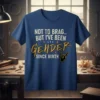 T-shirt with text "NOT TO BRAG... BUT I'VE BEEN GENDER SINCE BIRTH" in distressed white and gold font, featuring a