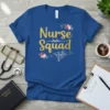 Gold glitter text "Nurse Squad" with floral accents and caduceus symbol on a blue t-shirt