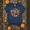Navy t-shirt with "OCTOPUS" in stylized text surrounded by pumpkins, leaves, and a swirl design, representing a fall octopus theme