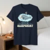 Official Sleepshirt text with a cute manatee sleeping on a cloud, moon and stars graphic
