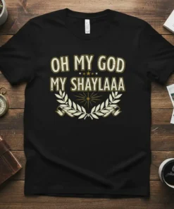Black t-shirt with "OH MY GOD MY SHAYLAAA" in bold gold lettering, surrounded by a laurel wreath graphic