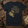 Old Habits Die Screaming quote with a vintage gold rose and flame graphic on a dark t-shirt