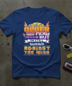 T-shirt with the quote "Well, I'm OLDER now BUT I'M STILL runnin AGAINST THE WIND" in bold retro typography, lightning