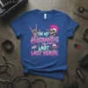 Graphic t-shirt with text "On My Husband's Last Last Nerve" in pink and blue, featuring skulls and rock hand gestures