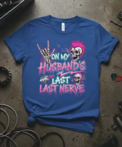 Graphic t-shirt with text "On My Husband's Last Last Nerve" in pink and blue, featuring skulls and rock hand gestures