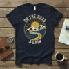 Navy t-shirt with "On The Road Again" text and a circular vintage graphic of mountains, ocean, and a winding road