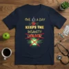 Funny "One A Day Keeps The Insanity Doctor" quote on a navy t-shirt with coffee cup and crossed-out apple graphics