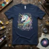 Navy t-shirt with "one of a kind" text and a colorful unicorn graphic surrounded by floral elements