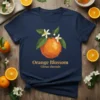 Orange Blossom Citrus sinensis text with a polygonal orange fruit and white blossoms on a navy t-shirt