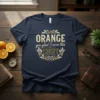 Navy t-shirt with "ORANGE you glad I wore this SHIRT" text in a laurel wreath design with oranges