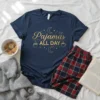 Navy blue t-shirt with gold text "Pajamas All Day" and celestial graphics, part of a cozy pajama set