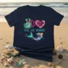 Peace Love Mermaids text with a tie-dye peace sign, coral heart, and a colorful mermaid graphic on a navy t-shirt