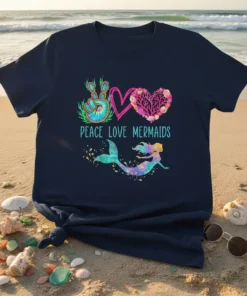 Peace Love Mermaids text with a tie-dye peace sign, coral heart, and a colorful mermaid graphic on a navy t-shirt