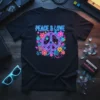 Black t-shirt with neon PEACE & LOVE text and a colorful peace symbol surrounded by flowers