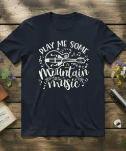 Play Me Some Mountain Music quote with acoustic guitar graphic and musical notes on a navy blue t-shirt