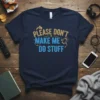 Navy blue t-shirt with gold and blue text reading "PLEASE DON'T MAKE ME DO STUFF," featuring a humorous introvert quote